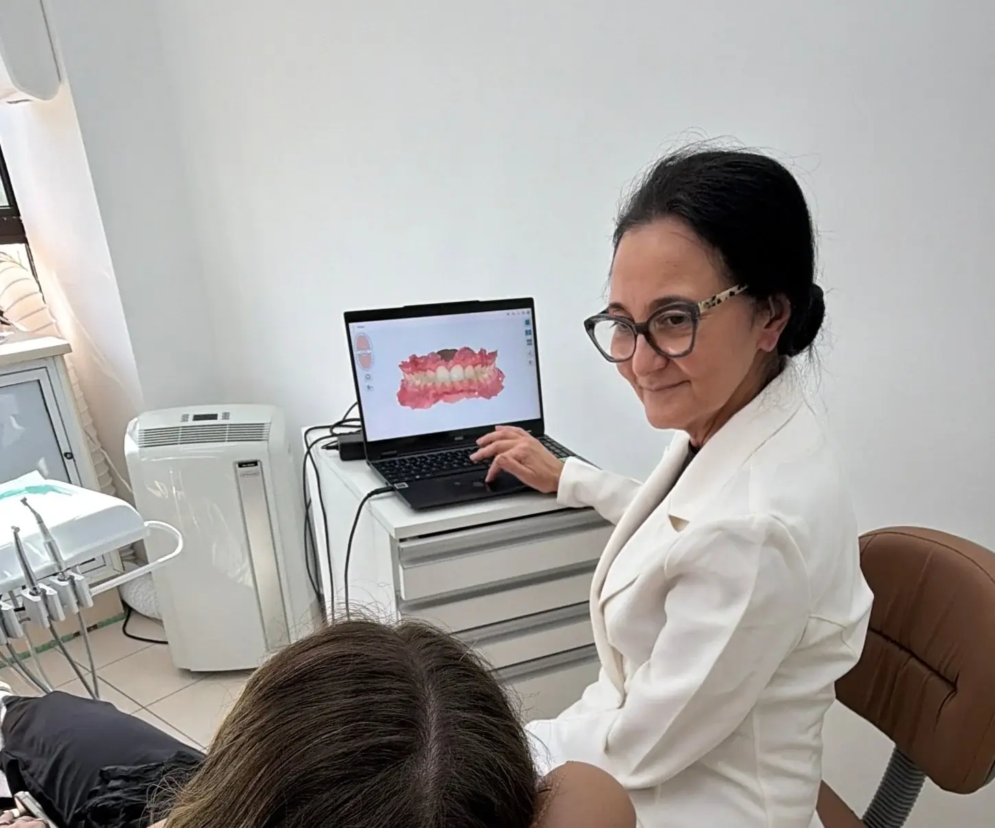 Dra. Cássia Lello mostrando o escaneamento à paciente
